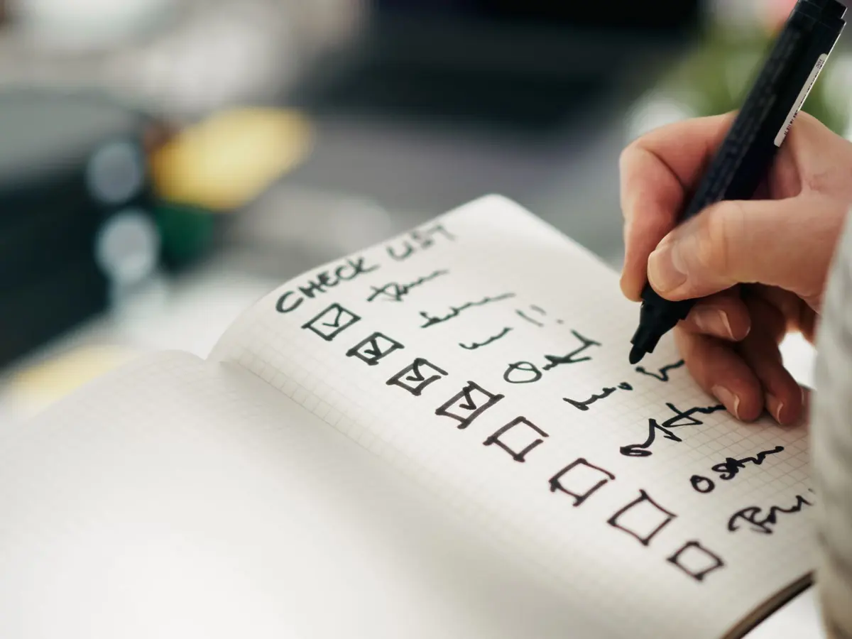A hand writing a to-do list